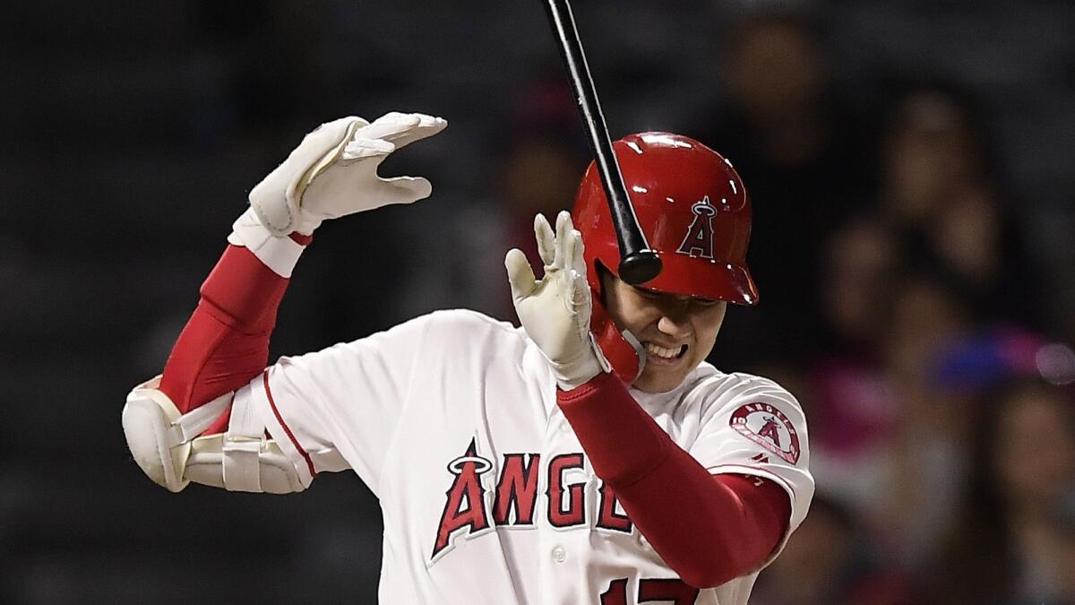 The Los Angeles Angels' Shohei Ohtani winces after he was hit on the hand while striking out in the eighth inning against the Minnesota Twins on May 20. Ohtani was hit on the ring finger of his right hand and will get checked on again Tuesday.