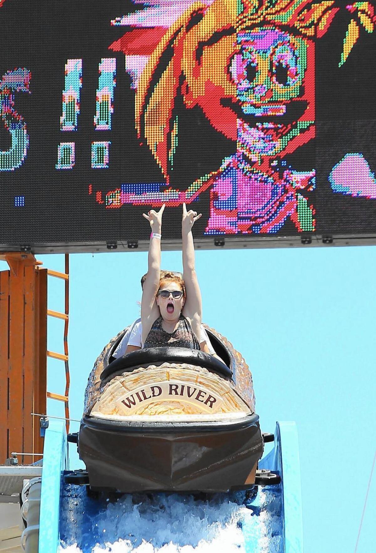 Nancy Glover raises her hands as she prepares to take the plunge on the Wild River log ride at the OC Fair.