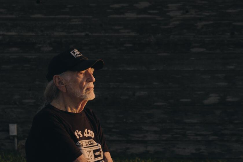 Willie Nelson sitting outside in a T-shirt