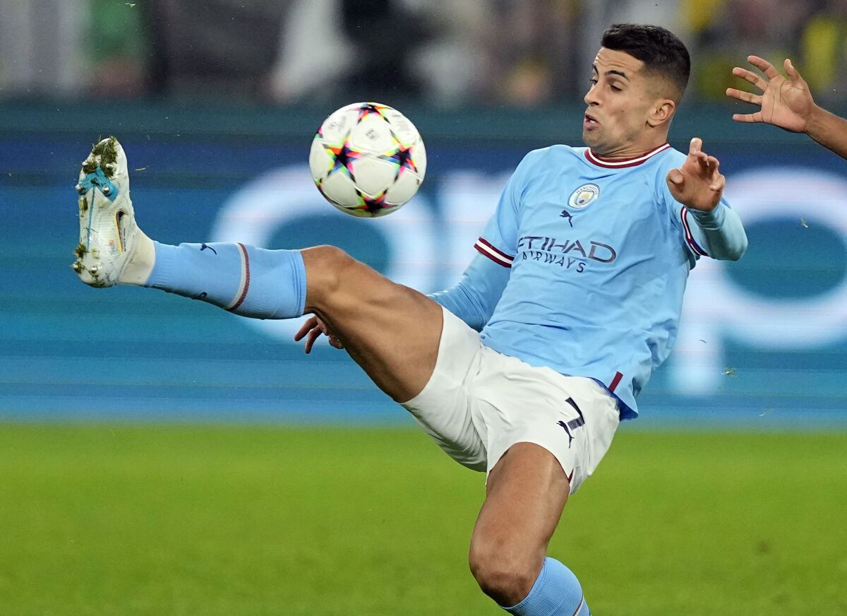 FILE -- Manchester City's Joao Cancelo, left, plays the ball during the Champions League Group G soccer match between Borussia Dortmund and Manchester City in Dortmund, Germany, Tuesday, Oct. 25, 2022. Bayern Munich has made an unexpected move to bolster its struggling team by signing Portugal left back Joao Cancelo on loan from Manchester City for the rest of the season. (AP Photo/Martin Meissner, file)
