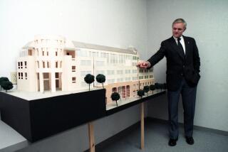 Bill Stacy, president of CSU San Marcos, shows model of one of the planned campus buildings in February 1990.