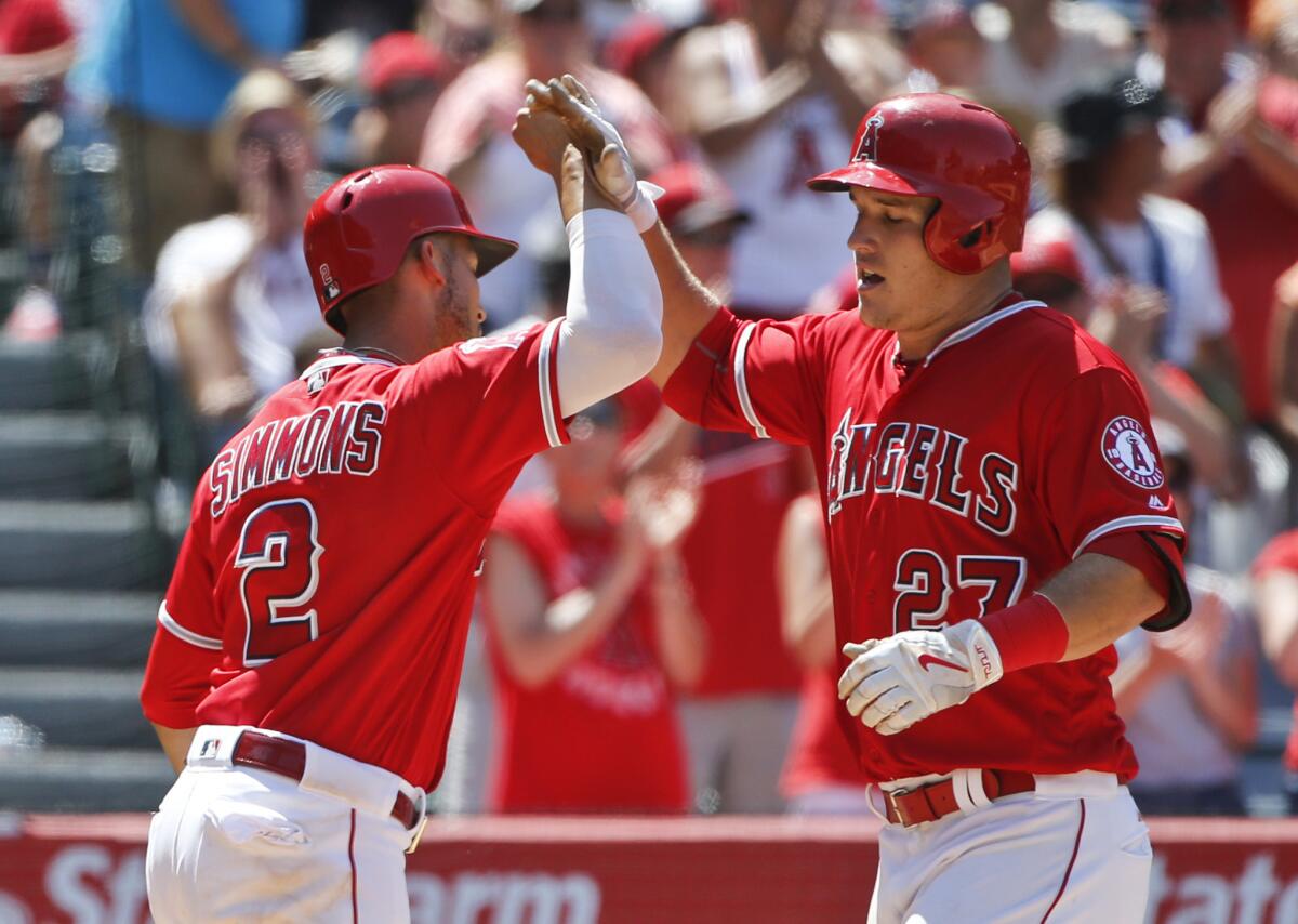 Angels outfielder Mike Trout (27) celebrates with shortstop Andrelton Simmons after hitting a two-run home run in the seventh inning.