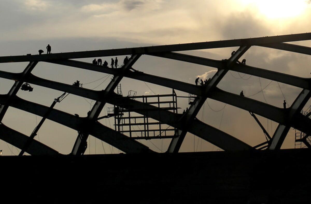 Workers construct part of the roof last week at the Arena da Amazonia stadium, in Manaus, Brazil, where a man fell to his death on Saturday.