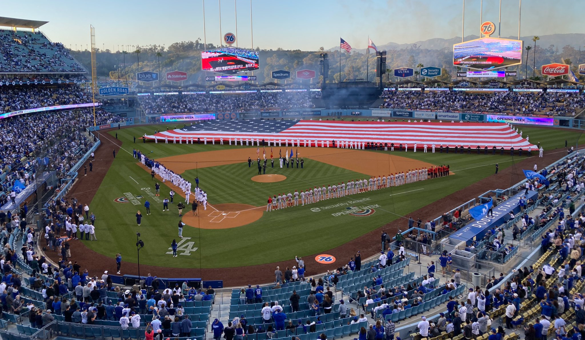 A giant American flag covers the field at Dodger Stadium before the start of the Dodgers' home opener
