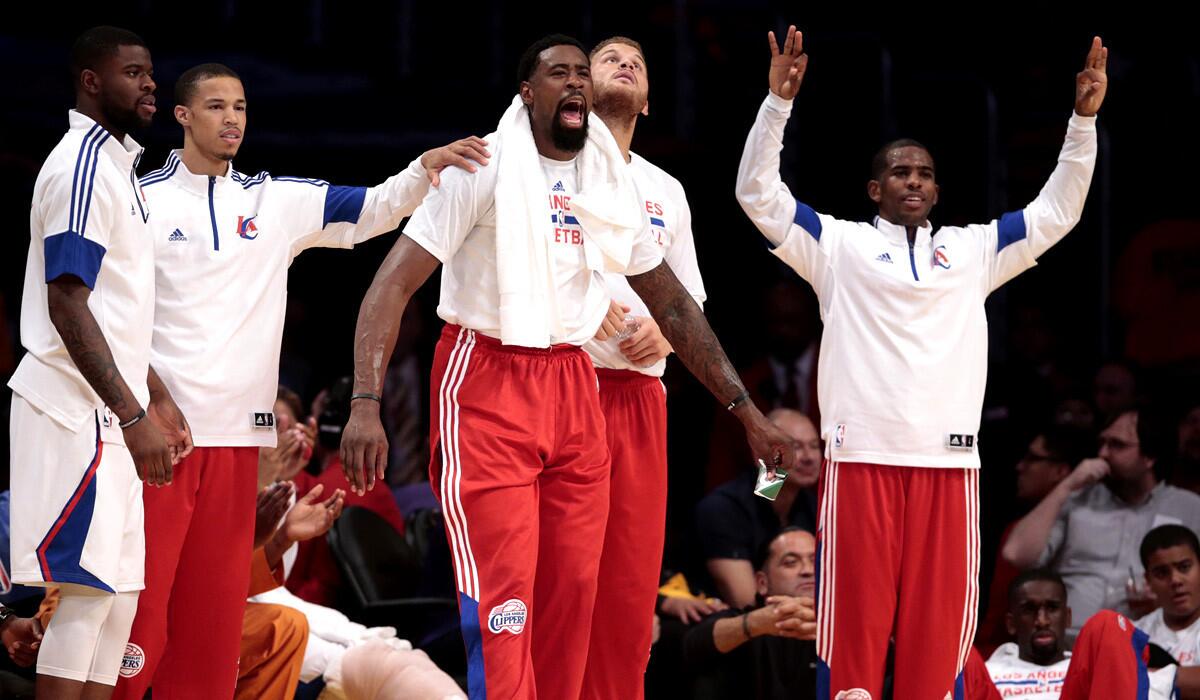 Clippers players, including starters DeAndre Jordan, Blake Griffin and Chris Paul, cheer from the bench after reserve guard Jamal Crawford made a three-point shot against the Lakers.