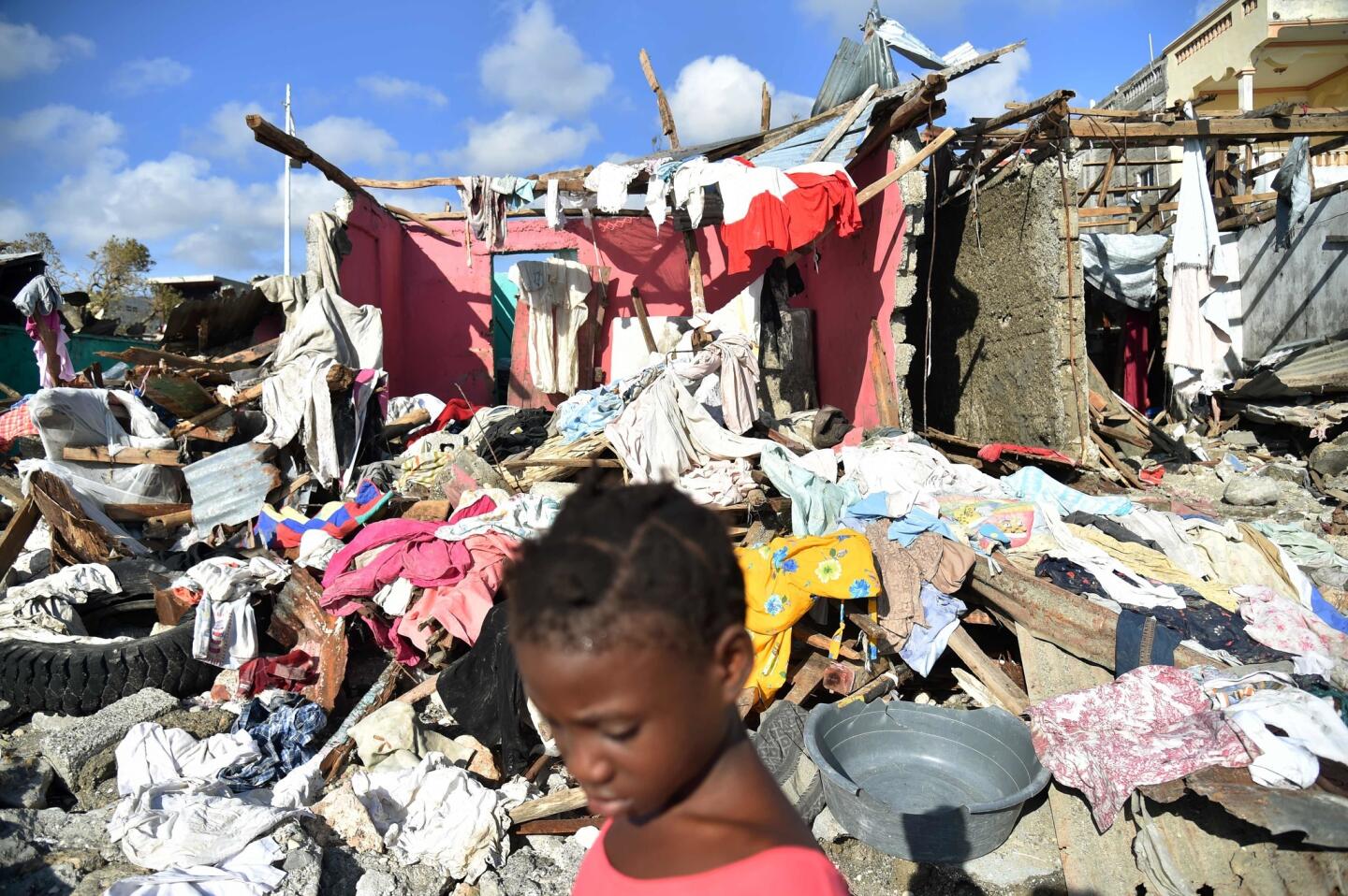 A girl walks in a beach next to the debris left by Hurricane Matthew in Jeremie, Haiti on Oct. 8, 2016.