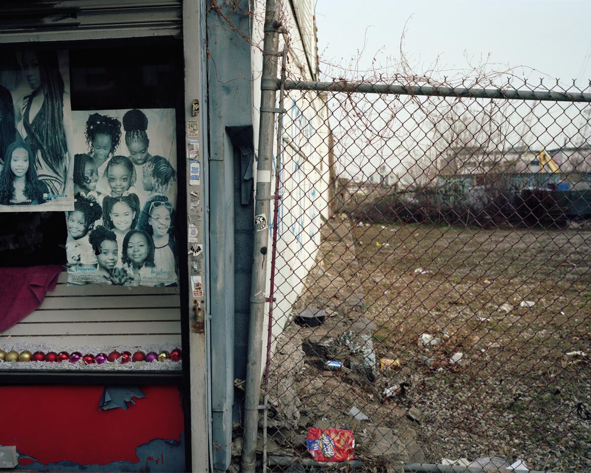 A photo that shows a poster of girls' hairstyles, ornaments and a vacant lot.