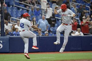 Los Angeles Angels' Mike Trout, right, celebrates with third base coach Eric Young Sr.