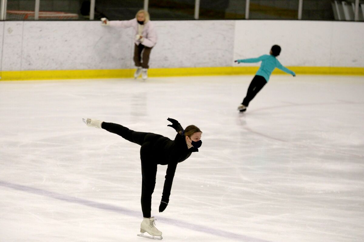 Figure skaters skate on the ice.