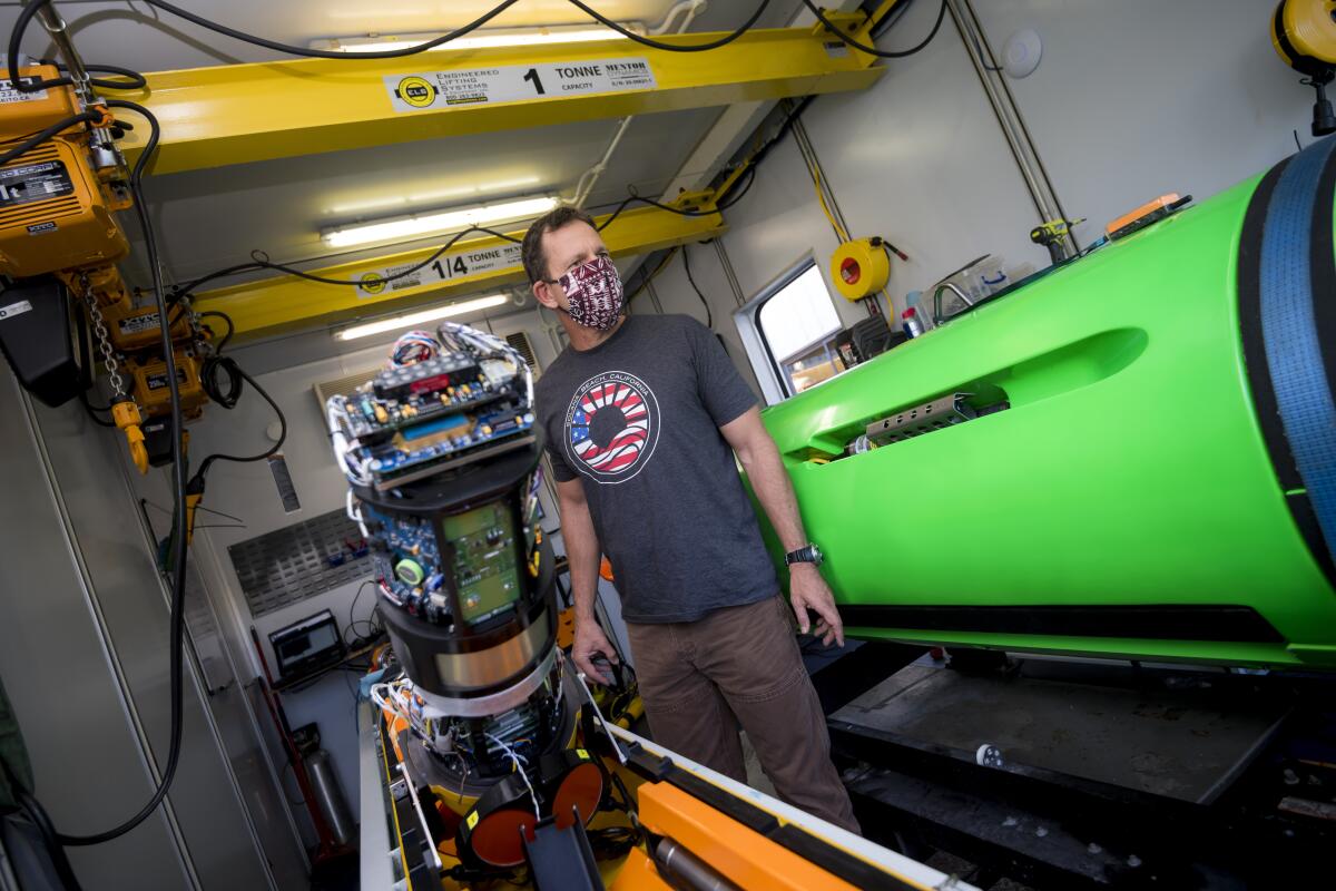 Eric Terrill prepares a REMUS 6000, an autonomous deep-sea vehicle that will map the seafloor with side-scan sonar.