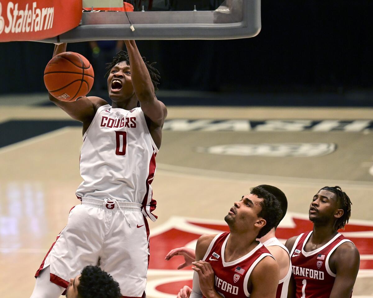 FILE - In this Saturday, Feb. 20, 2021 file photo, Washington State center Efe Abogidi, left, dunks the ball next to Stanford forward Oscar da Silva (13) during the first overtime of an NCAA college basketball game, in Pullman, Wash. A serious knee injury nearly ended Efe Abogidi's basketball career but he's now back on the NBA draft radar. The 19-year-old Nigerian is known for his high-flying dunks and plays for Washington State in the Pac-12. But his journey from West Africa to the West Coast was atypical with stops in Senegal and Australia. (AP Photo/Pete Caster, File)