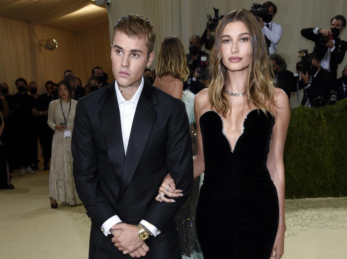 Justin Bieber and Hailey Bieber in black formal wear posing next to each other at the Met Gala