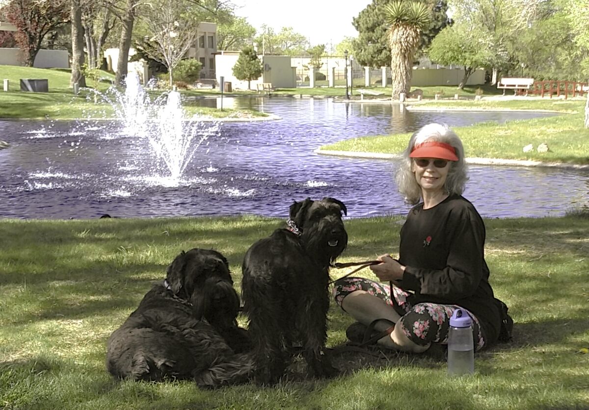 Penny Wagner appears with her two dogs, Clarence, left, and Cooper in Albuquerque, N.M., on April 8, 2020. Clarence died peacefully March 9 after Wagner and her husband hired a private service that provides home euthanasia for pets. (Steve Wagner via AP)