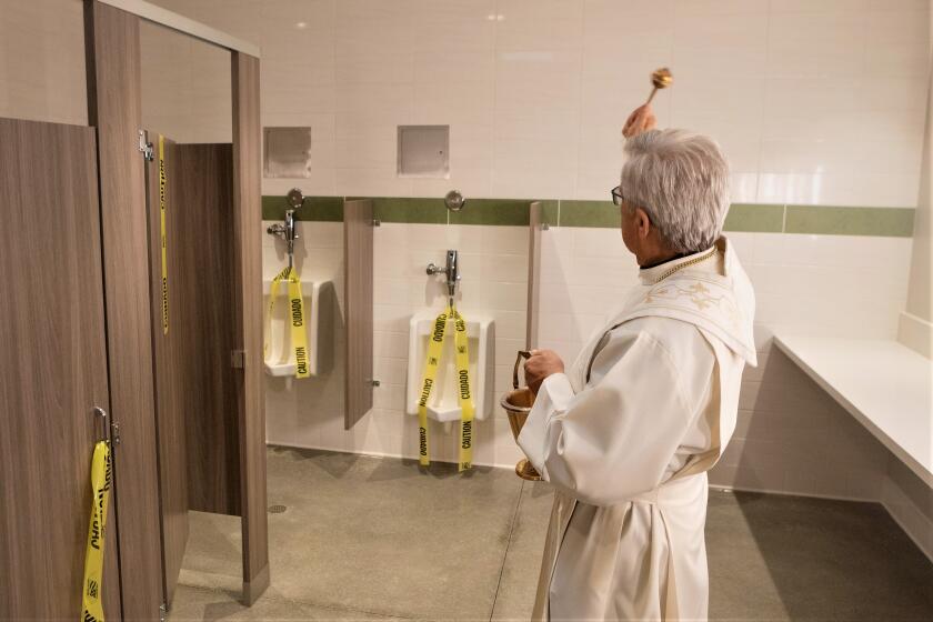 Fr. Mike Hanifin blesses the new restrooms at Saint Joachim Catholic Church in Costa Mesa, which took years to fund.