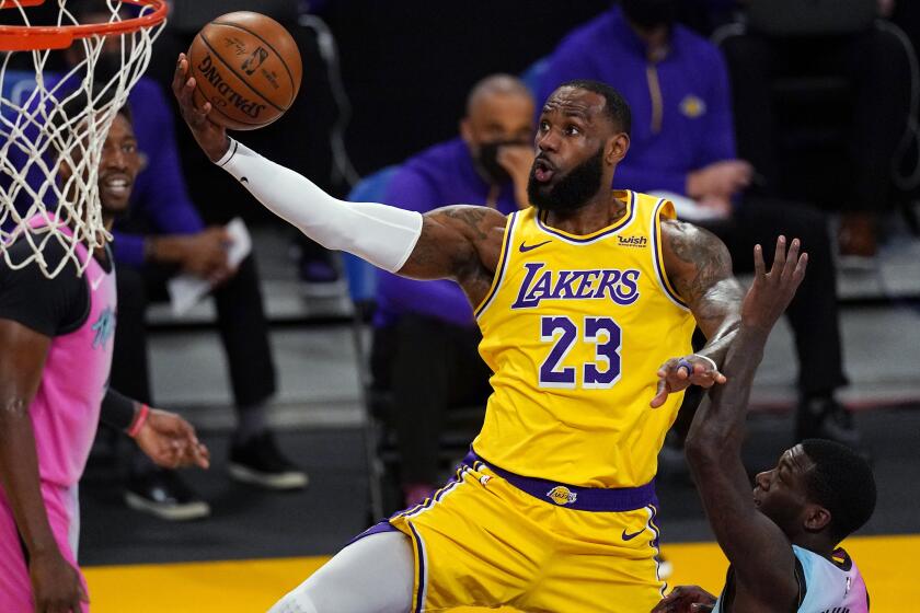 Los Angeles Lakers forward LeBron James shoots as Miami Heat guard Kendrick Nunn.
