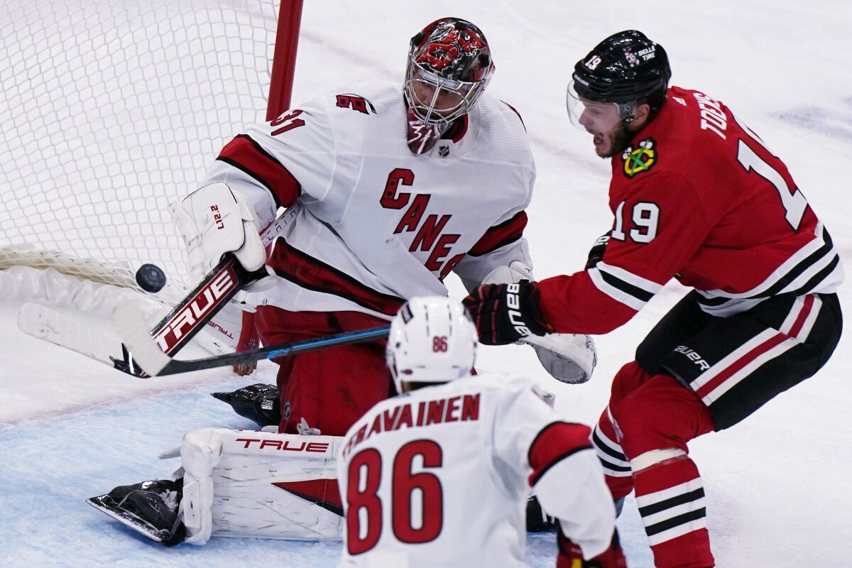 Carolina Hurricanes goaltender Frederik Andersen, left, makes a save on a shot by Chicago Blackhawks center Jonathan Toews during the third period of an NHL hockey game in Chicago, Wednesday, Nov. 3, 2021. The Hurricanes won 4-3. (AP Photo/Nam Y. Huh)