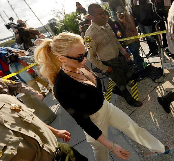 Lindsay Lohan arrives at Airport Courthouse for a court proceeding on felony grand theft charges on Feb. 23. About 40 paparazzi stood ready by the concrete walkway and nine television trucks parked nearby. In the air, a chopper for KTLA followed Lohan's drive from the Venice home where she is living to the courthouse.