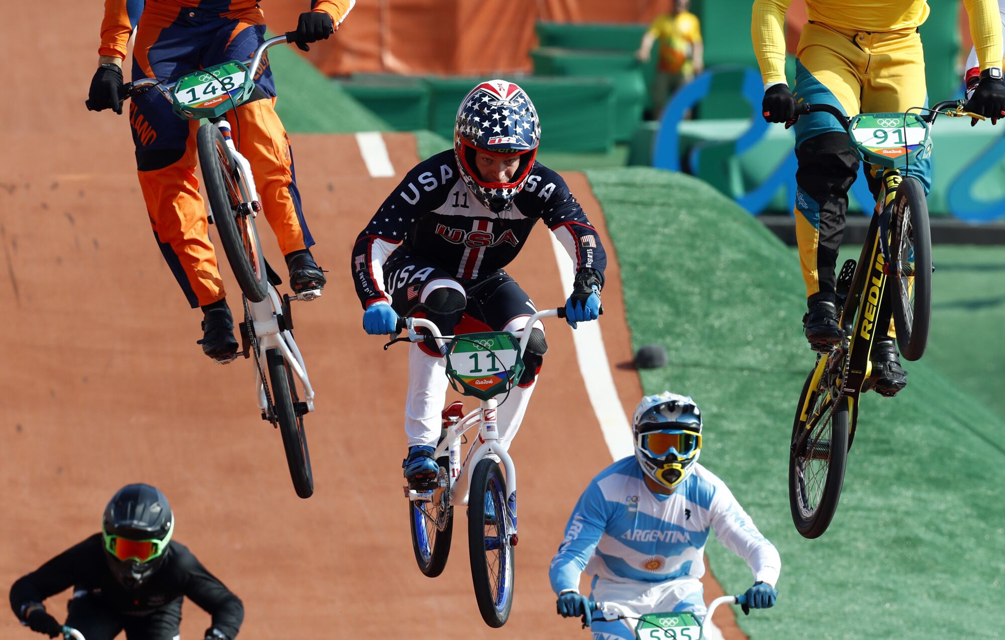 BMX bikers are suspended in midair.