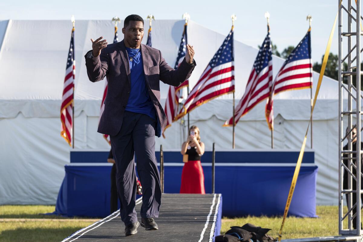 FILE - Senate candidate Herschel Walker takes the stage during former president Donald Trump's Save America rally in Perry, Ga., on Saturday, Sept. 25, 2021. Walker canceled a planned Texas fundraiser on Wednesday, Oct. 13 because an organizer was displaying a swastika made from syringes on social medial to protest mandatory vaccination. (AP Photo/Ben Gray, File)