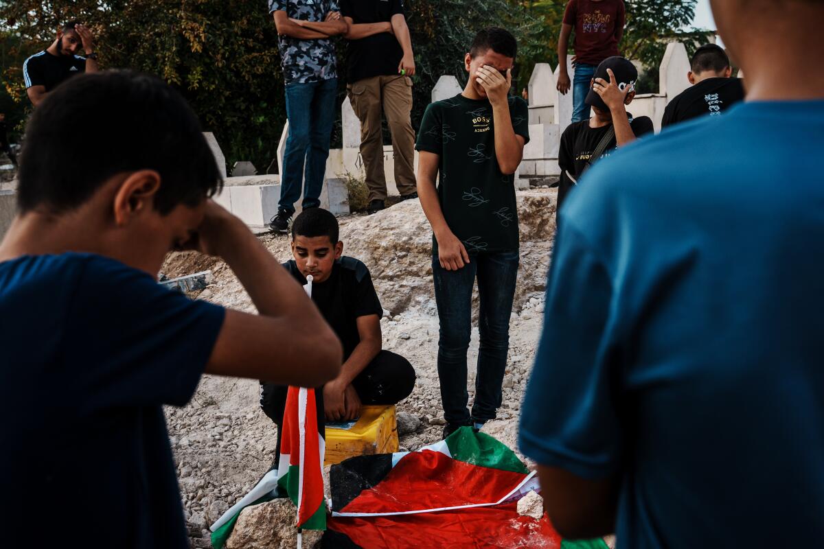 Two men stay behind to bid farewell to their slain friend in Tulkarem, occupied West Bank.