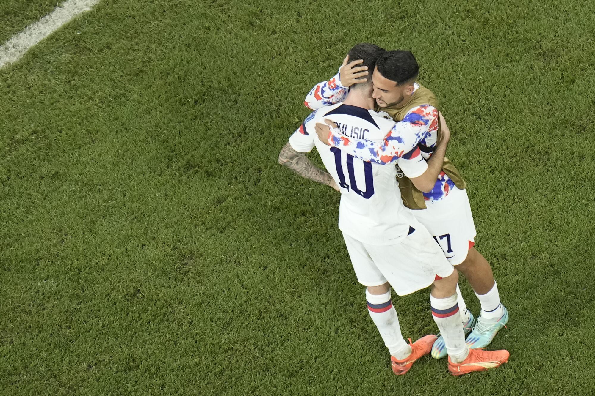 U.S. players Christian Pulisic of the United States, left, and Cristian Roldan hug after the team's loss to the Netherlands.