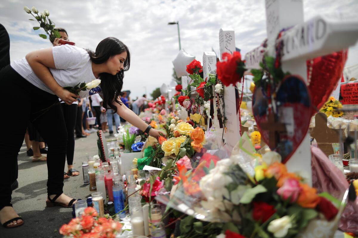 A woman places flowers at a makeshift memorial for victims of a mass shooting at a Walmart in El Paso, Texas, that left 22 people dead in August.