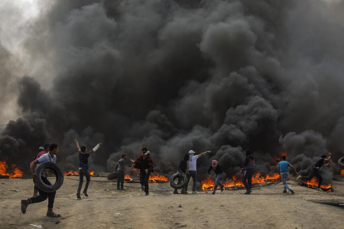 Palestinians burn tires to reduce visibility for Israeli forces at the border fence separating Israel and Gaza.