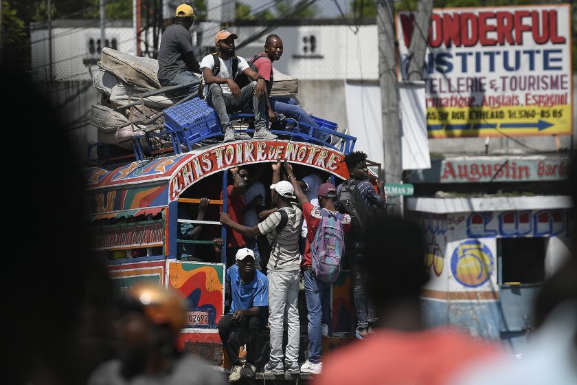 Commuters ride a Tap Tap bus in Port-au-Prince, Haiti, Wednesday, Oct. 20, 2021. (AP Photo/Matias Delacroix)