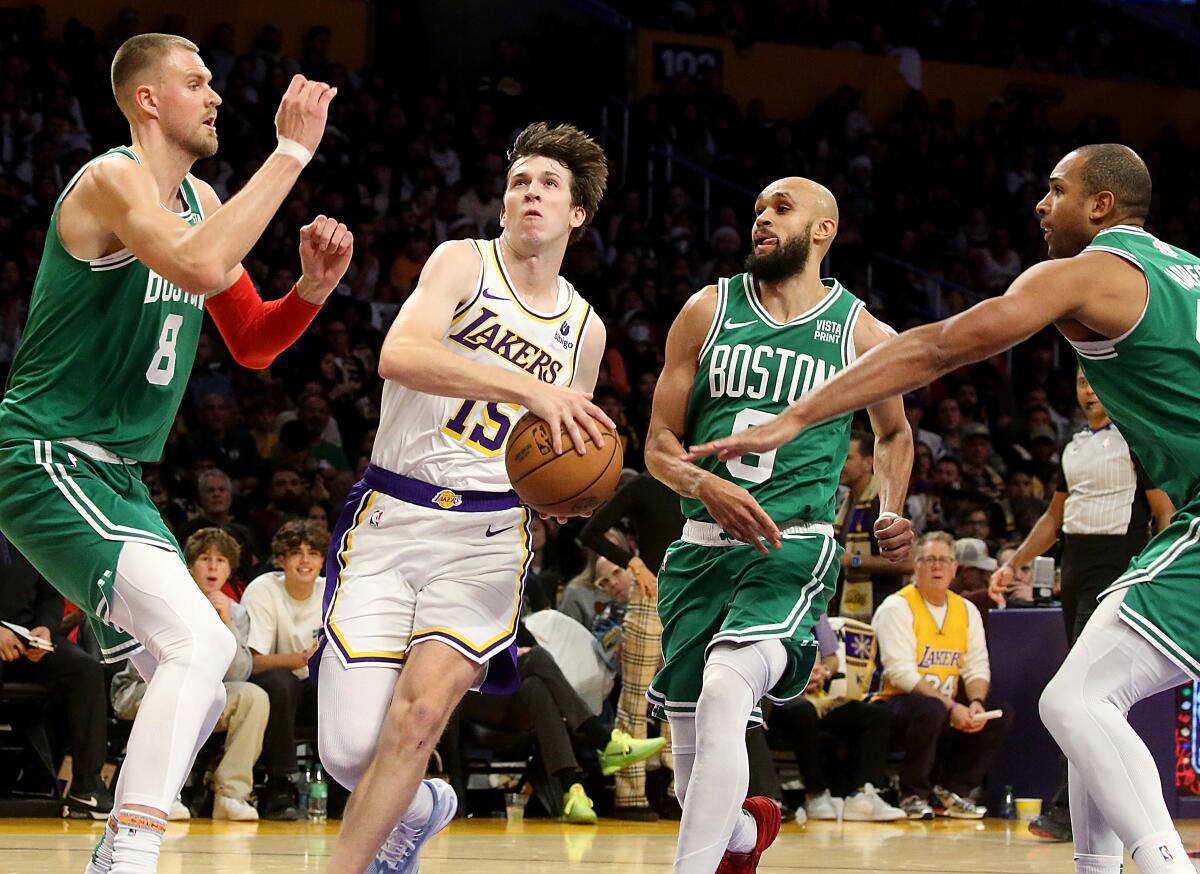 Lakers guard Austin Reaves, center, drives through the Boston Celtics defense.