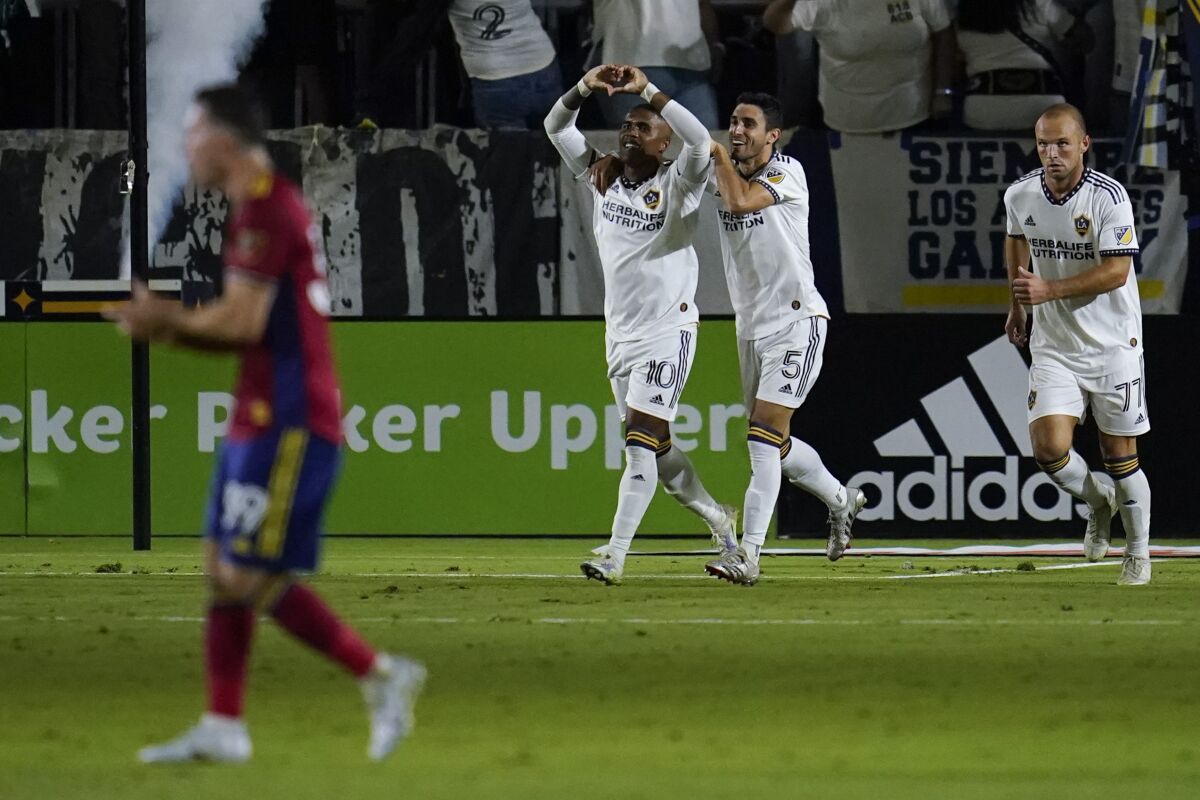 LA Galaxy forward Douglas Costa (10) celebrates with midfielder Gaston Brugman (5) after scoring during the second half of an MLS soccer match against the Real Salt Lake in Carson, Calif., Saturday, Oct. 1, 2022. (AP Photo/Ashley Landis)