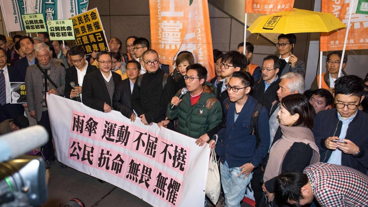 Activists from Hong Kong's Umbrella Movement speak to supporters before their arrest in Hong Kong on March 27, 2017.