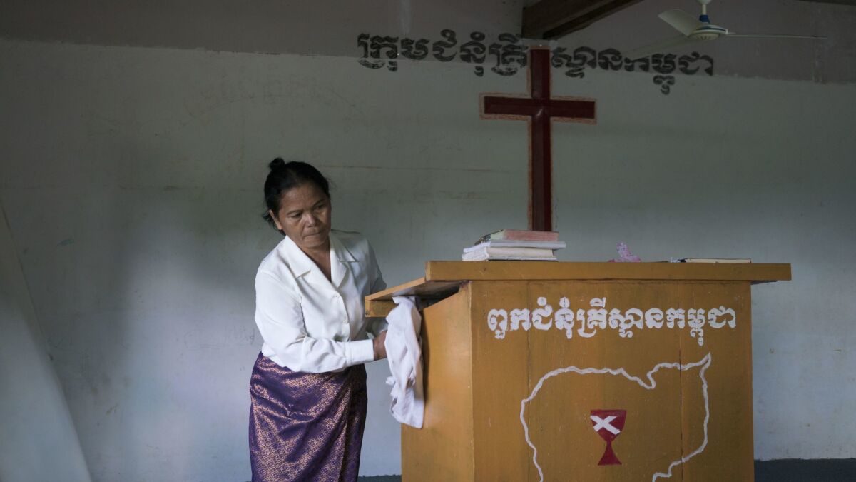 Morm Phin, 75, prepares for Sunday service. Morm was working as a supervisor in a garment factory during the Khmer Rouge's regime and she is now a pastor in a small church outside Pailin town.