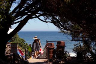 MALIBU, CA - AUGUST 10, 2022 - - A visitor and her family make it to the top of the stairs at Lechuza Beach from the top of the stairs in Malibu on August 10, 2022. (Genaro Molina / Los Angeles Times)