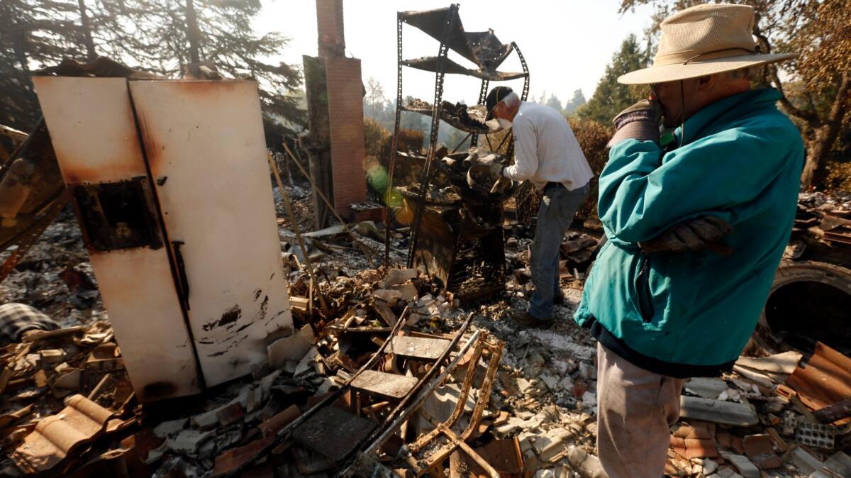 California fire victims can call for free help with landlord-tenant issues, mortgage foreclosure concerns and questions about life, medical and property insurance. Above, Chris Shaw, 74, surveys his destroyed home in Wikiup.