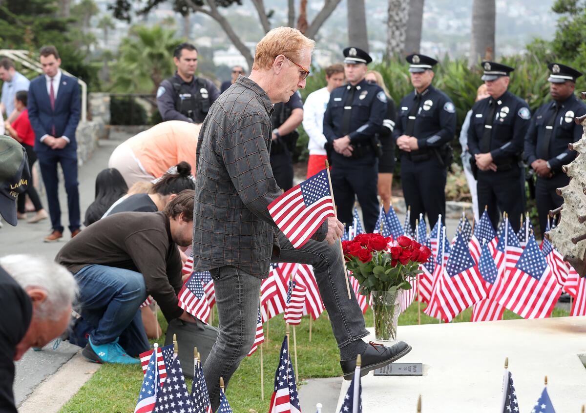 Artist Jorg Dubin steps toward the "Semper Memento" sculpture to post a flag.