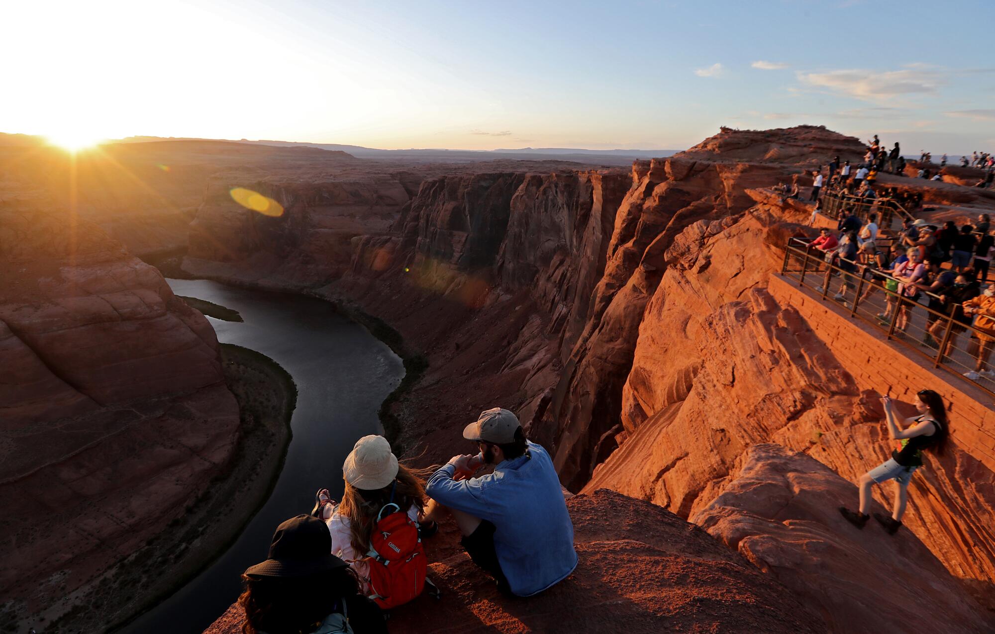 Visitors get a view and pictures of the sun setting on Horseshoe Bend on the Colorado River