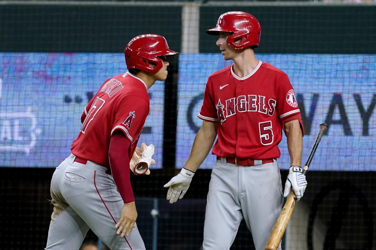 The Angels' Shohei Ohtani and Matt Duffy celebrate after Ohtani scored on Taylor Ward's double.