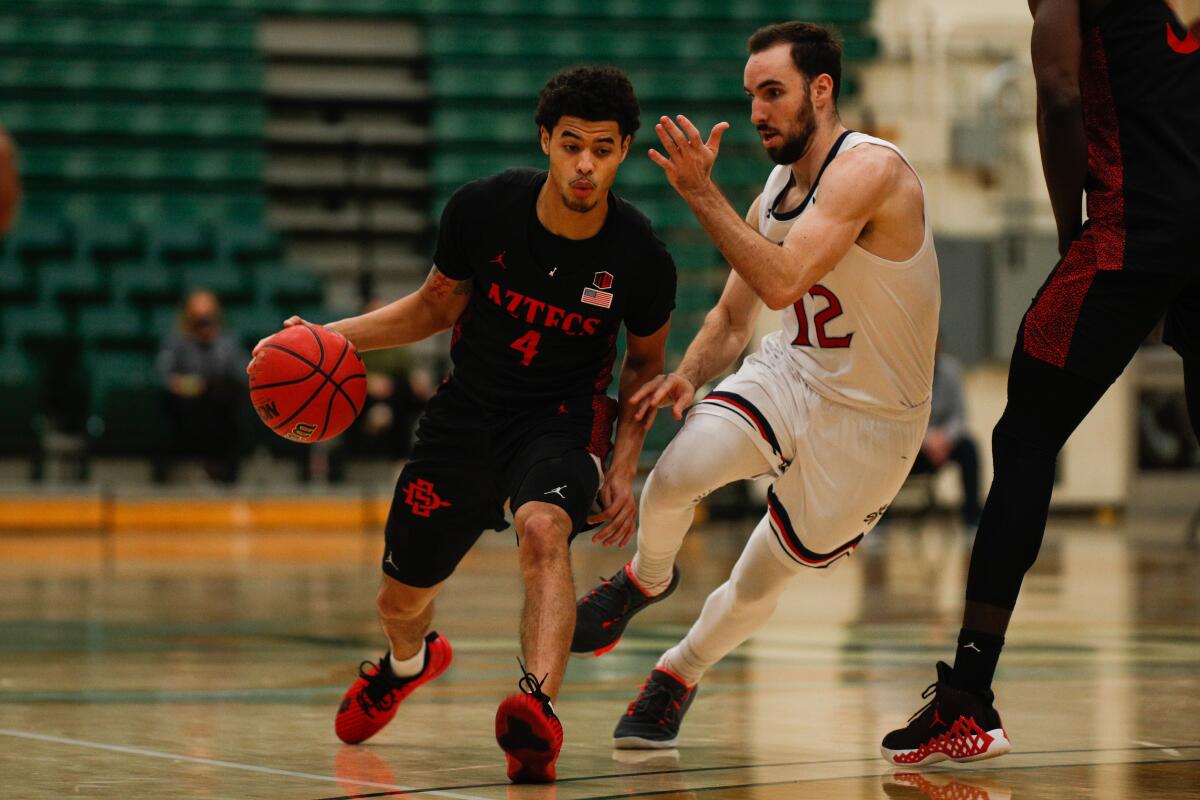 SSDSU's Trey Pulliam (4) dribbles against St. Mary's guard Tommy Kuhse in a 74-49 Aztecs win last season at Cal Poly.