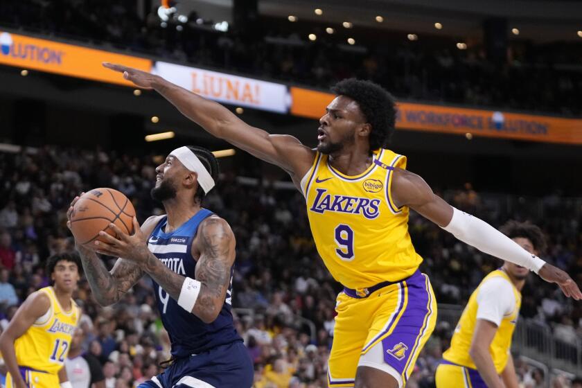 Minnesota Timberwolves guard Nickeil Alexander-Walker, center, shoots as Los Angeles Lakers.