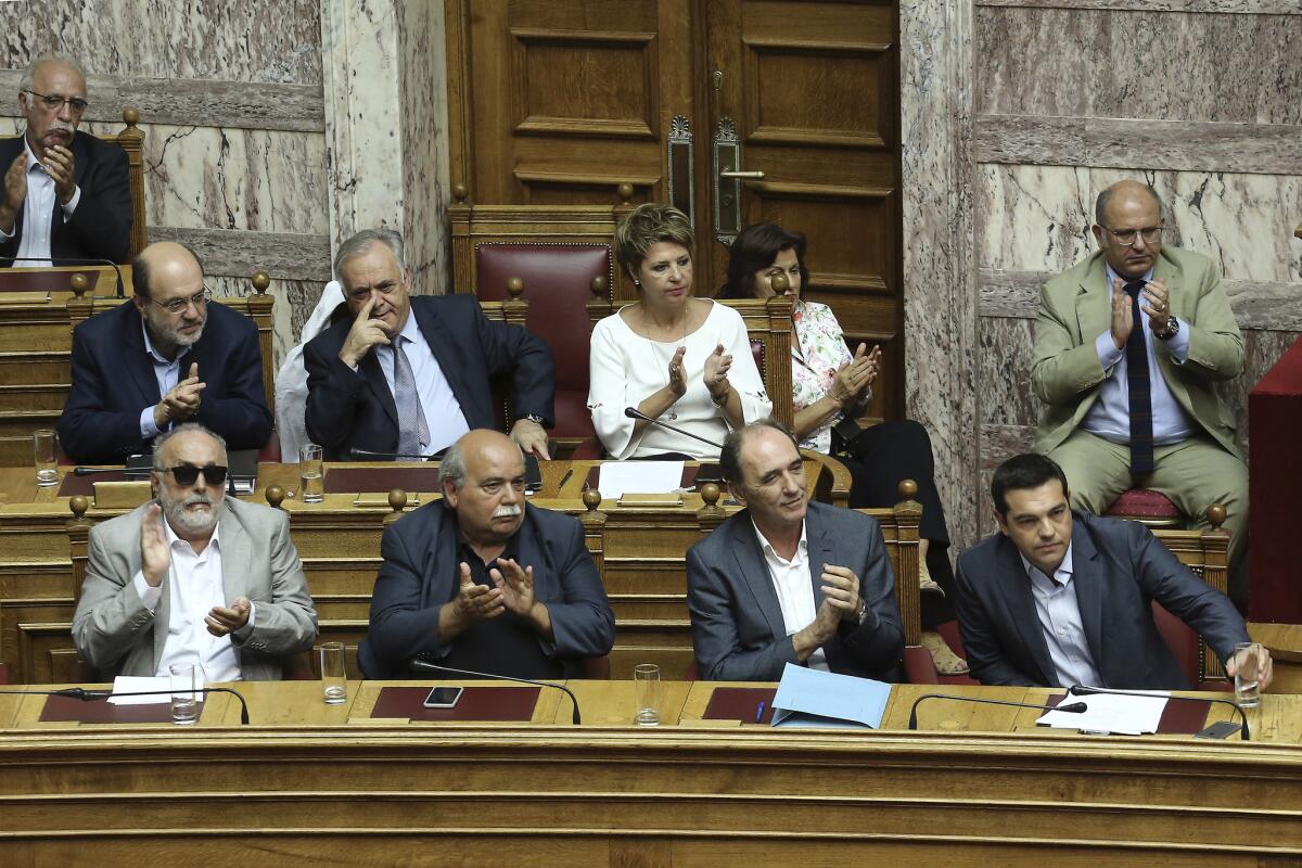 Greek Prime Minister Alexis Tsipras, front right, acknowledges applause after speaking at a parliamentary session in Athens on Aug. 14.