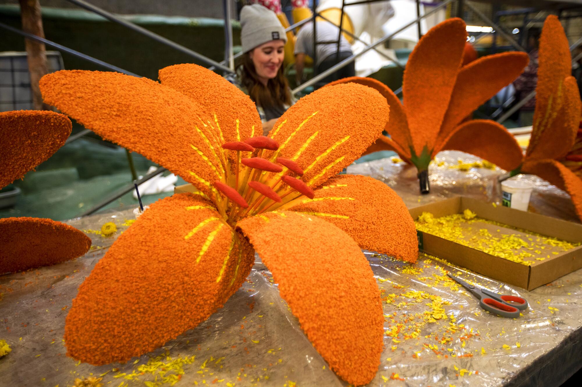 A human-size orange "flower" is ready for a float 
