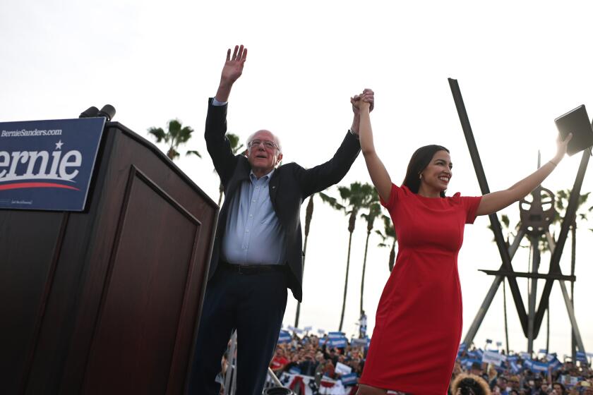 TOPSHOT - US Democratic presidential candidate Bernie Sanders (L) campaigns with Rep. Alexandria Ocasio-Cortez (D-NY) in the Venice Beach neighborhood of Los Angeles, California, December 21, 2019. (Photo by Robyn Beck / AFP) (Photo by ROBYN BECK/AFP via Getty Images)