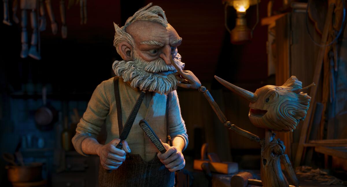 An animated older man holds tools, left, while a wooden boy pokes his nose in the movie "Pinocchio." 