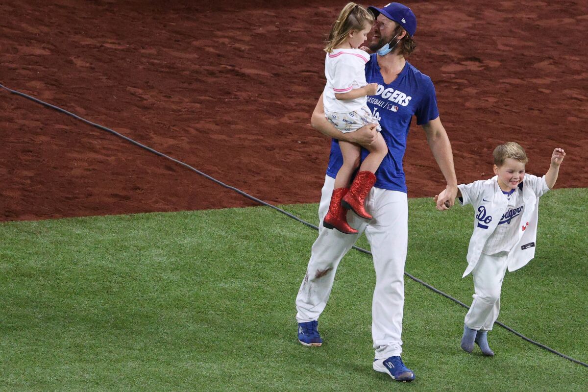 Clayton Kershaw of the Los Angeles Dodgers celebrates with his daughter Cali Ann and son Charley.