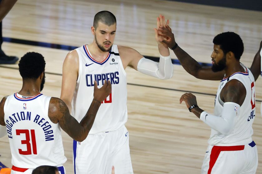 Los Angeles Clippers' Ivica Zubac, center, is congratulated by teammates Marcus Morris Sr. (31) and Paul George (13) during an NBA basketball game against the New Orleans Pelicans, Saturday, Aug. 1, 2020, in Lake Buena Vista, Fla. (Kevin C. Cox/Pool Photo via AP)