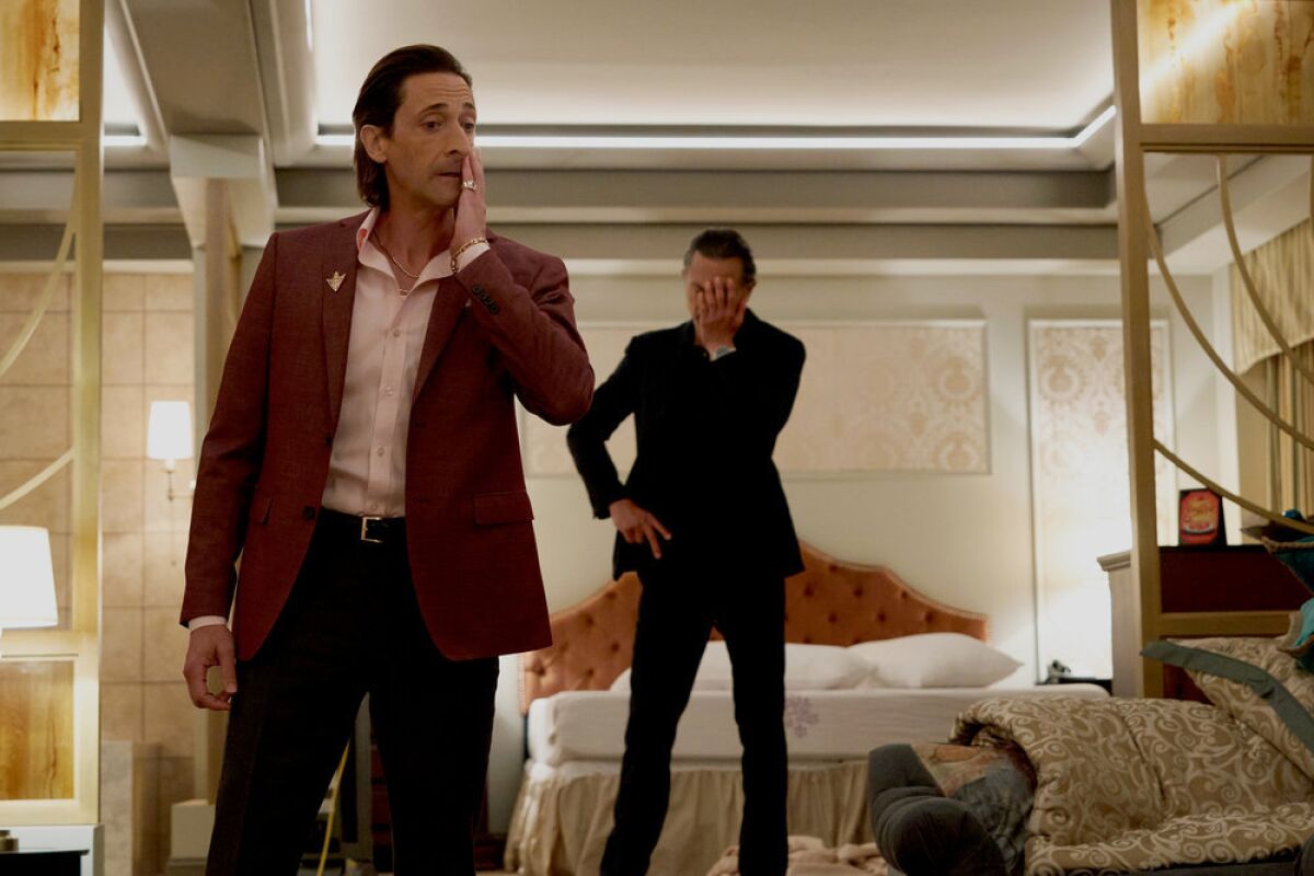 Two men standing a hotel room looking dismayed in a scene from "Poker Face."