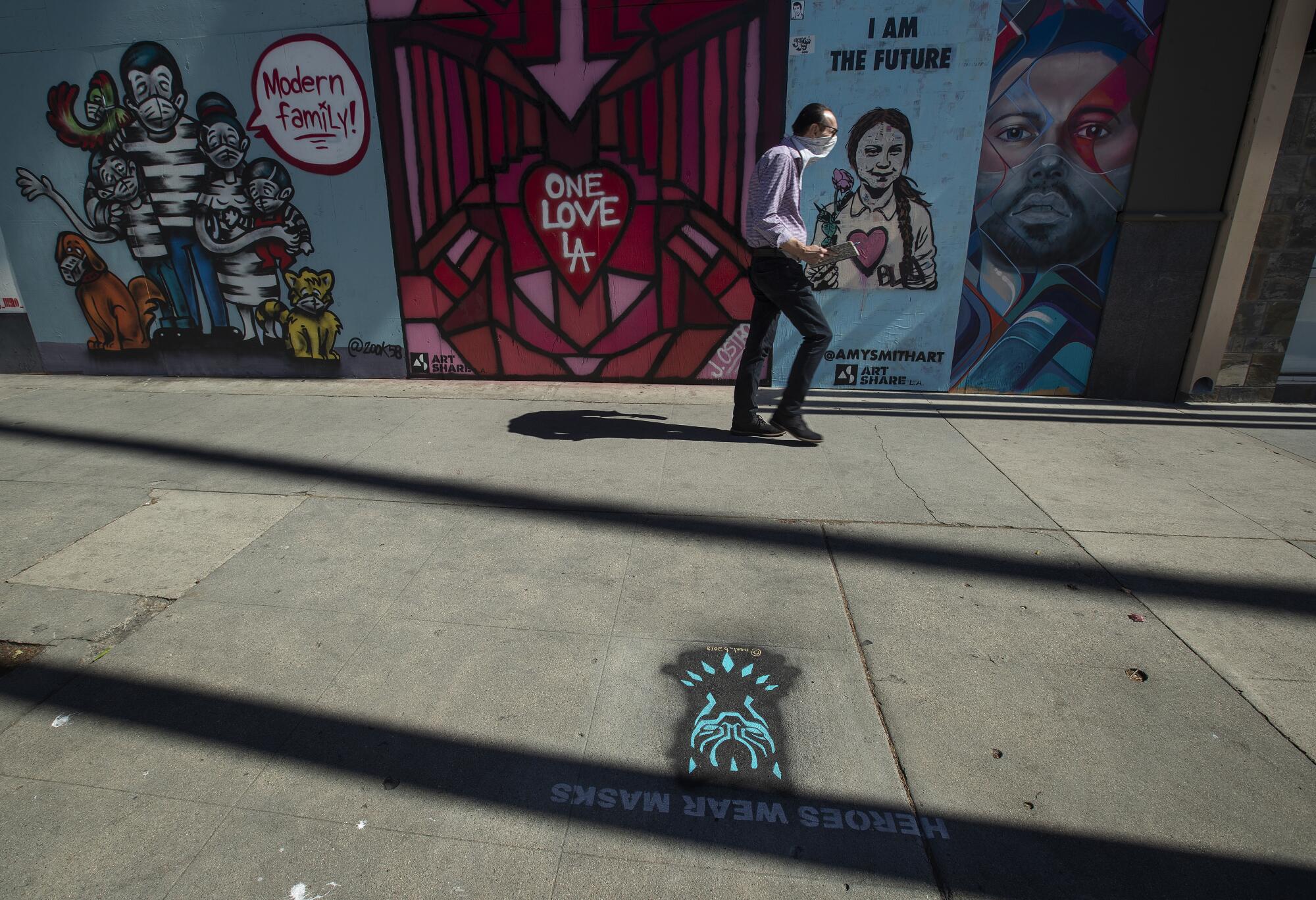 "Heroes Wear Masks" artwork is seen on the sidewalk along Ventura Boulevard in Studio City.