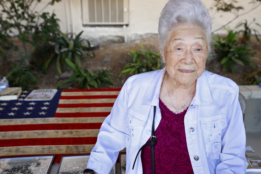 SAN DIEGO, CA - SEPTEMBER 19: With the intent to recognize surviving Japanese Americans of the WWII incarceration camps for their sacrifice, and to honor their legacy and memory, Judge Johnny Gogo, a California Superior Court Judge from San Jose obtained a WWII-era 48-star American flag with the intent of having survivors sign the flag. Here, Yukiko Sugiyama, 100, was in Poston Internment Camp in Yuma visited flag at the Buddhist Temple of San Diego on Sunday, Sept. 19, 2021. (K.C. Alfred / The San Diego Union-Tribune)