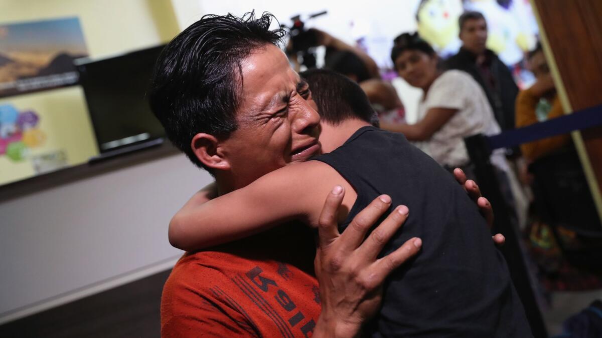 A father embraces his son in Guatemala City. The boy was among nine children flown from New York and reunited with their families in August, months after U.S. border agents deported the parents.