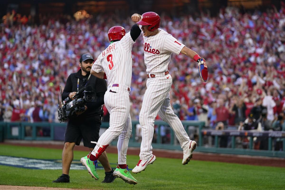 Philadelphia Phillies' Rhys Hoskins (17) celebrates with Bryce Harper (3) after hitting a three-run home run during the third inning in Game 3 of baseball's National League Division Series against the Atlanta Braves, Friday, Oct. 14, 2022, in Philadelphia. (AP Photo/Matt Slocum)